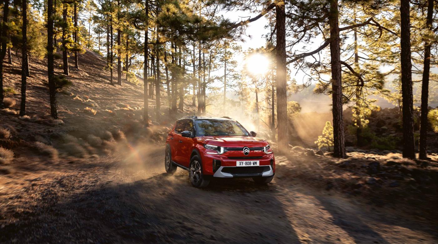 Citroën Aircross Max Híbrida roja en una carretera de bosque
